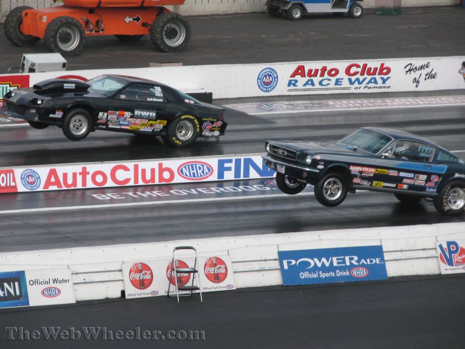 1967 Ford Mustang drag car and a black Camaro drag car on a race track