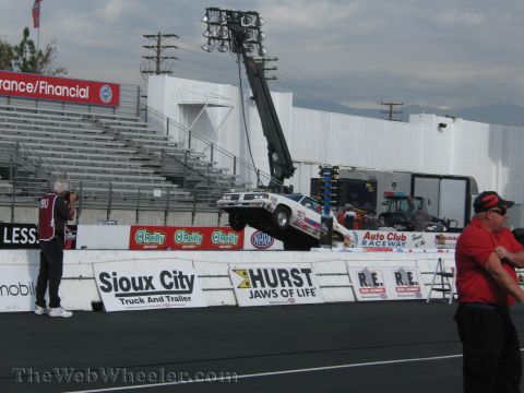 1968 Ford Mustang - A drag racing car is being lifted by a crane after an incident on the track.