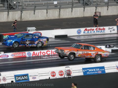 1968 Ford Mustang - A 1968 Ford Mustang competes in a drag race, its wheels lifted off the ground.