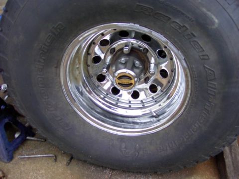1980 Ford Bronco - A close-up view of a vehicle's tire and chrome wheel, with visible tire brand markings.