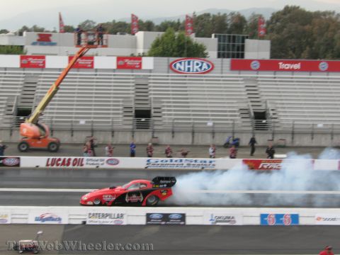 1968 Ford Mustang - A drag racing car performs a burnout at a NHRA event, generating a large cloud of smoke.