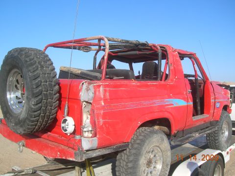 1985 Ford Bronco - This red 1985 Ford Bronco is on a trailer, modified for off-road use with a roll cage.