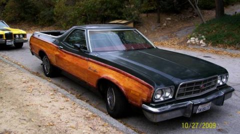 1973 Ford Ranchero - A 1973 Ford Ranchero with distinctive wood grain side panels is parked curbside, with another vehicle visible behind it.