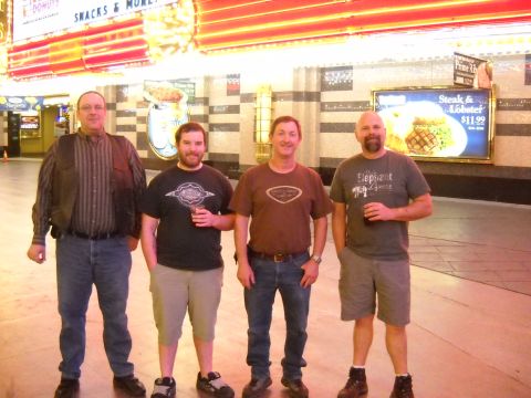 1986 Ford Bronco II - Four men pose for a photo in front of a restaurant advertisement and neon lights.