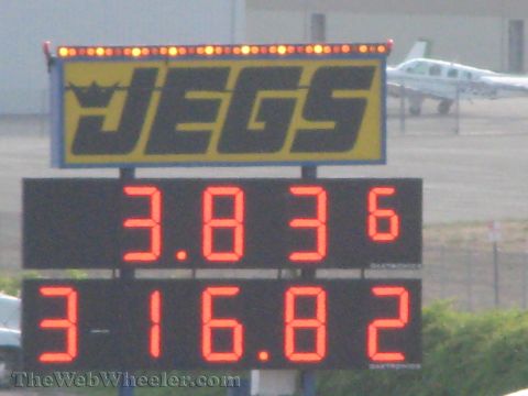 1968 Ford Mustang - A JEGS scoreboard shows race times, with a small airplane visible in the background at what appears to be an airfield or drag strip.