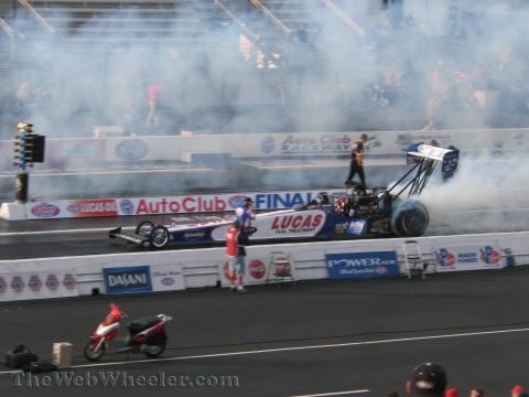 1968 Ford Mustang - A dragster is on the track at Auto Club Raceway during the NHRA finals.