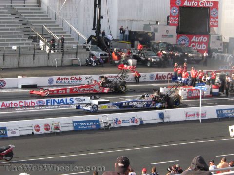 1968 Ford Mustang - Drag racing cars compete at the Auto Club NHRA Finals, with prominent sponsorships visible on their bodies.