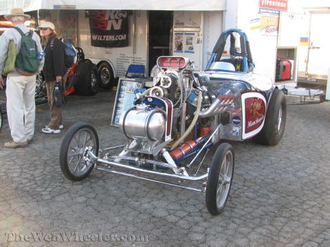 1968 Ford Mustang - A dragster with a prominent engine and K&N Filters branding is displayed at an event.