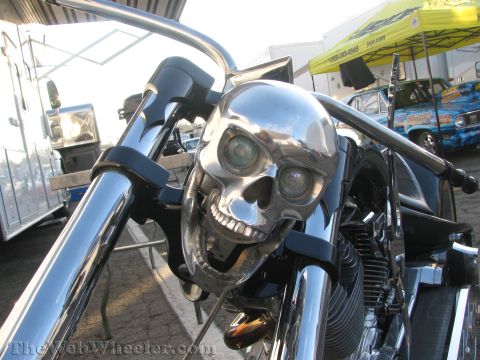 1968 Ford Mustang - A custom motorcycle features a chrome skull headlight and handlebars, with other vehicles in the background.