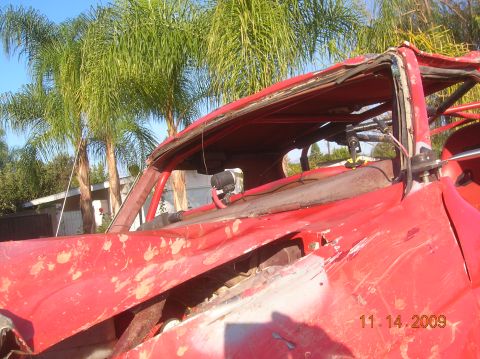 1985 Ford Bronco - The interior of a heavily damaged red off-road vehicle is visible, with a roll cage and palm trees in the background. The date 11.14.2009 i…