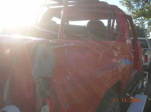 1985 Ford Bronco - The red SUV shows significant damage, with repairs visible on the body panels. A date stamp indicates the photo was taken on 11.14.2009.