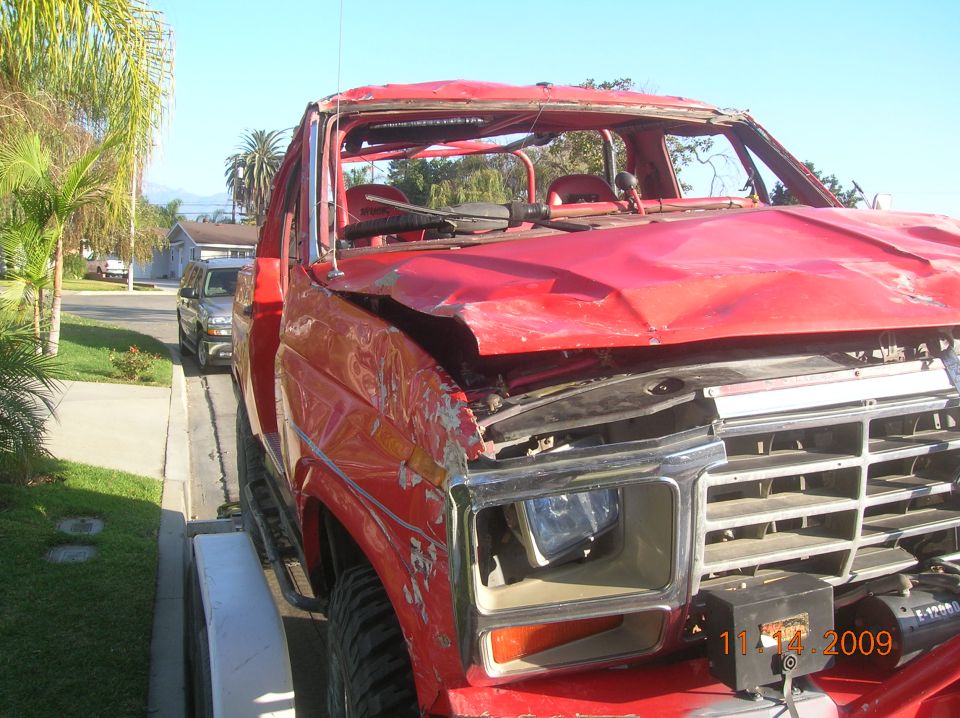 Red truck with damaged front end and missing windshield. Date stamp reads 11/14/2009