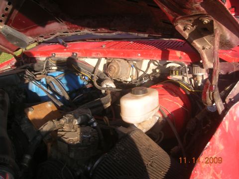 1985 Ford Bronco - The engine bay of a red vehicle is visible, showing various components and wiring. A date stamp indicates the photo was taken on November 1…