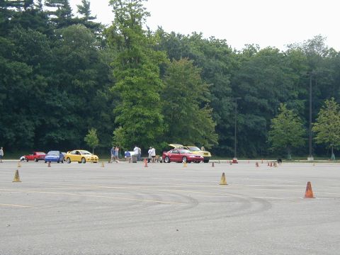 1994 Ford Mustang - A red 1994 Ford Mustang is parked in a lot with other cars and cones, suggesting an event.
