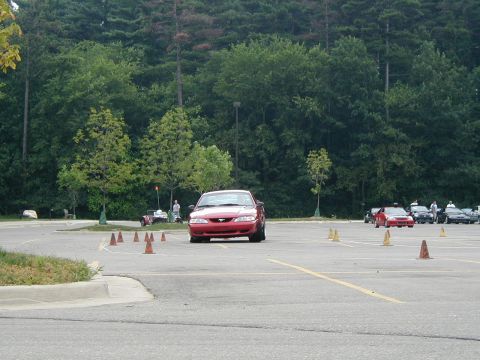 1994 Ford Mustang - A red 1994 Ford Mustang navigates a course marked by traffic cones on a sunny day.