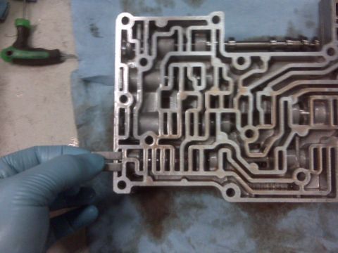 1994 Ford F-150 - A close-up view of an automatic transmission valve body, showing its intricate internal passages.
