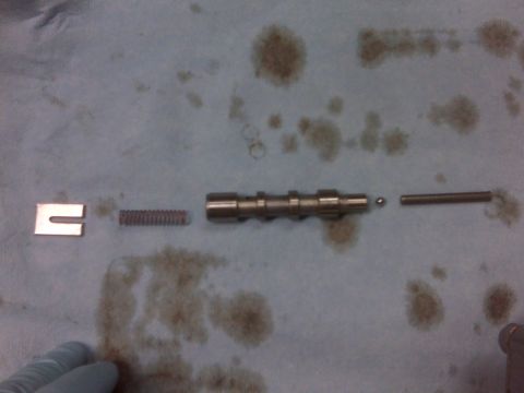 1994 Ford F-150 - Engine components laid out on a cloth, including a camshaft-like piece, spring, and ball bearing.