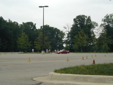 1994 Ford Mustang - Red 1994 Ford Mustang coupe navigating a cone course in a parking lot.