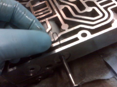 1994 Ford F-150 - A gloved hand manipulates a small metal clip within the intricate channels of an automatic transmission valve body.