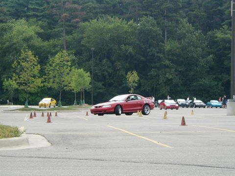 1994 Ford Mustang - A red 1994 Ford Mustang navigates an auto-cross course, with its front-left tire lifted.