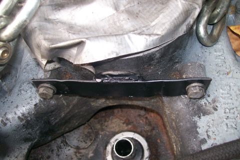 1992 Ford C-350 (Centurion Conversions) - Close-up view of an engine mount bracket, showing bolts and metal construction.