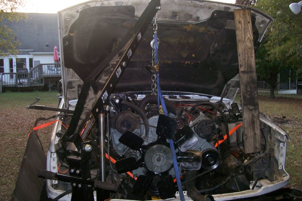Engine bay with engine hoist and engine removed, white truck