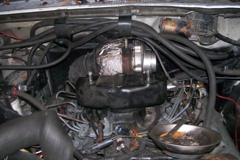 1992 Ford C-350 (Centurion Conversions) - Close-up view of an engine bay, focusing on the turbocharger and associated plumbing. Text from SuperMotors.net is visible.