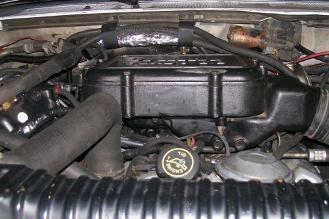 1992 Ford C-350 (Centurion Conversions) - Close-up view of the engine bay, focusing on the engine components and associated hoses.
