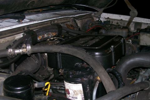 1992 Ford C-350 (Centurion Conversions) - Close-up view of an engine bay, focusing on the engine components and associated hoses.