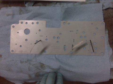 1994 Ford F-150 - A metal plate with many holes and some damage is shown, possibly a component from a vehicle.