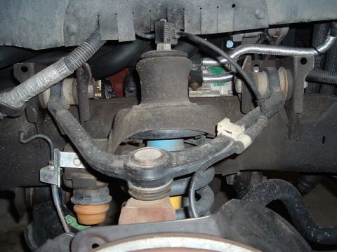 2007 Ford Mustang - Front suspension components of a vehicle, including control arms and a ball joint.