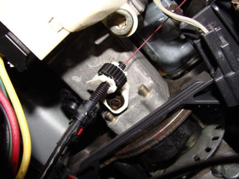 2007 Ford Mustang - Close-up view of a throttle cable mechanism, showing its internal components and wiring.