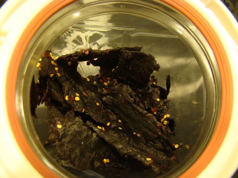 1989 Ford Bronco - Close-up of beef jerky with visible chili flakes stored in a jar.