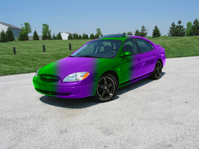 Purple and green sedan with mismatched paint, viewed from the front three-quarter angle