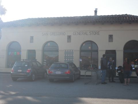 1991 Ford Bronco - A dark blue hatchback and a dark sedan are parked outside the San Gregorio General Store, with a motorcycle also visible.