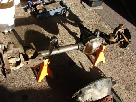 1996 Jeep Grand Cherokee - A disassembled front axle assembly rests on jack stands, with tools nearby.