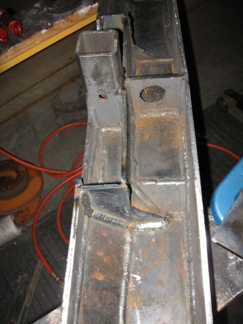 1995 Ford F-150 - Close-up of a welded metal frame section, showing fabrication work with square tubing and various attachment points.