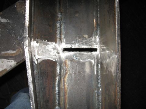 1995 Ford F-150 - This image shows a section of a metal frame with extensive welding and a small rectangular opening.
