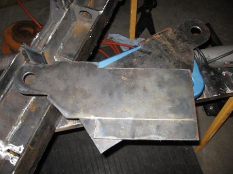 1995 Ford F-150 - Close-up view of a metal bracket being welded onto a vehicle's frame, secured with a blue clamp.
