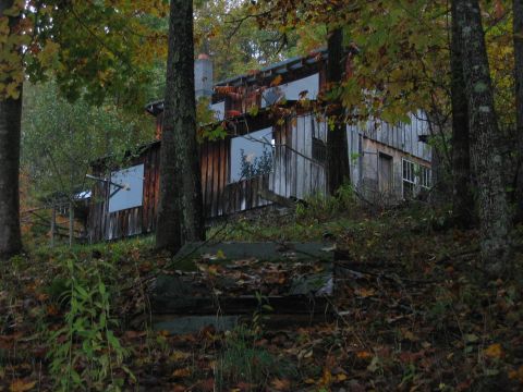 1992 Ford Bronco - A rustic wooden cabin sits amongst trees during the fall season.