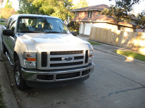 2008 Ford F-250 - This 2008 Ford F-250 pickup truck is parked on a residential street, showing its front grille and headlights.