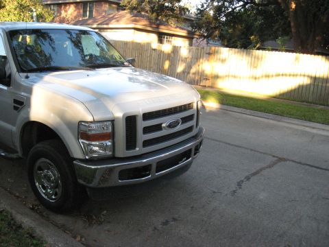 2008 Ford F-250 - A silver Ford Super Duty truck is parked on a residential street, showing its front grille and headlights.