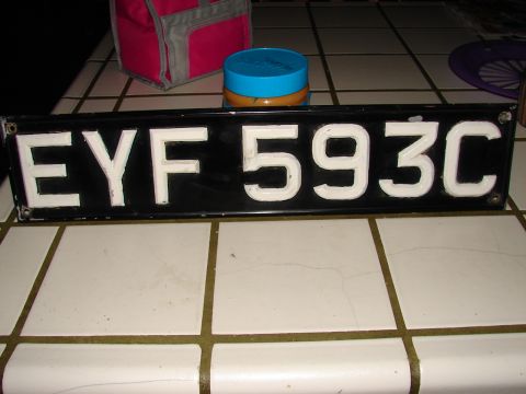 1973 Ford Ranchero - A black license plate with white characters EYF 593C is displayed on a tiled surface.