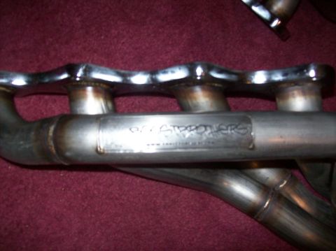 2007 Ford Mustang - Close-up of exhaust headers with a visible brand name and website address.