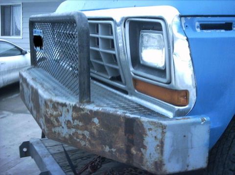 1954 Ford F-100 - This truck features a prominent chrome grille and a heavy-duty, rusty bumper, likely from the 1970s.