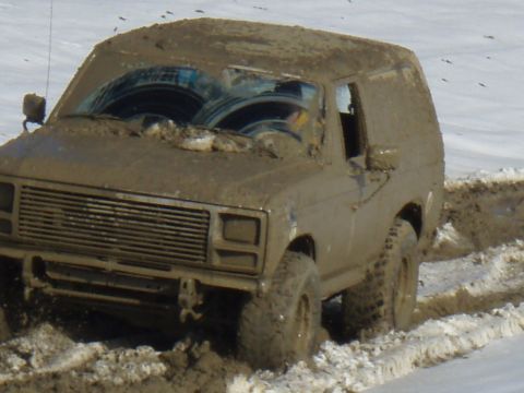 1985 Ford Bronco - Muddy 1985 Ford Bronco navigating a difficult off-road course.