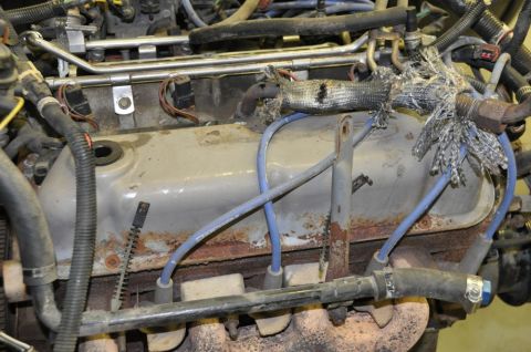1996 Ford Bronco - The engine bay shows signs of wear and tear, with some wiring insulation damaged.