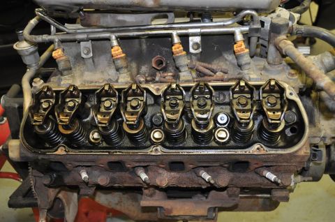 1996 Ford Bronco - Close-up view of an engine's valve train and fuel injection system, likely during a tear-down or repair process.