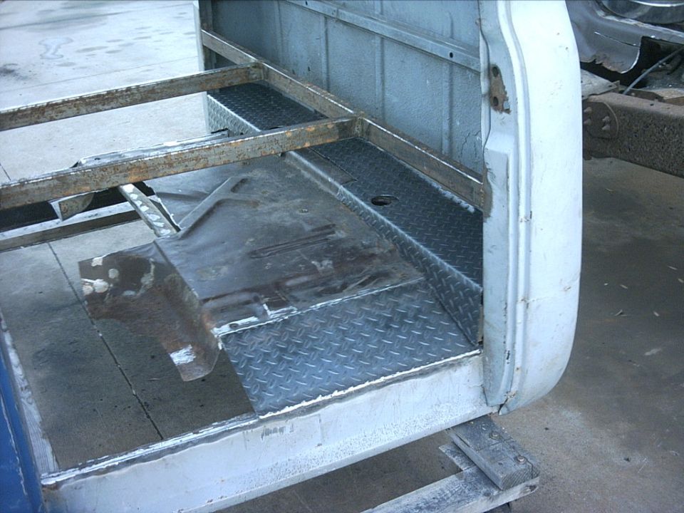 Bare truck cab floor with diamond-plate panel and door opening