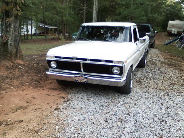 White Ford F-100 pickup truck parked on a gravel driveway